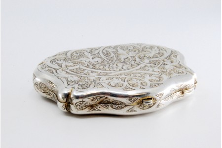 Porta moedas em prata com motivos vegetalistas gravados e três divisões em tecido no interior.